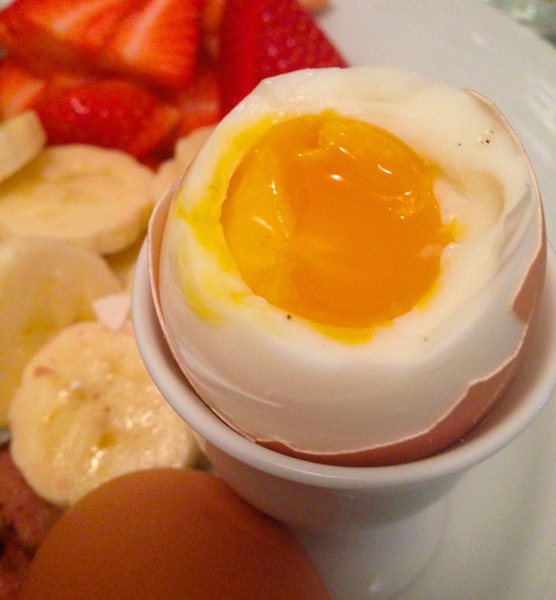 Soft boiled eggs with fruit and avocado for breakfast